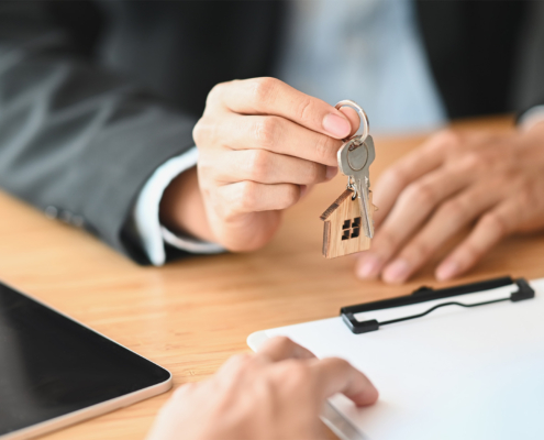 Cropped shot of House broker giving a property key to his customer