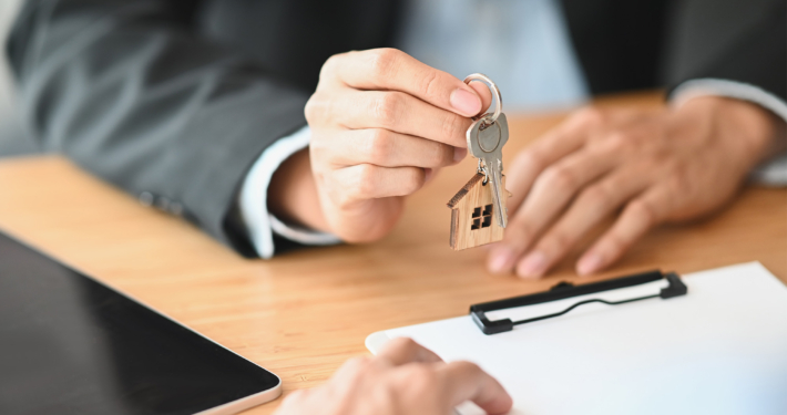 Cropped shot of House broker giving a property key to his customer