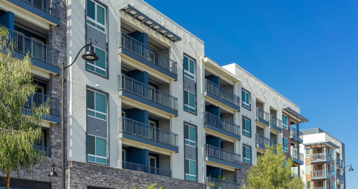 New modern apartment building with balconies and blue sky