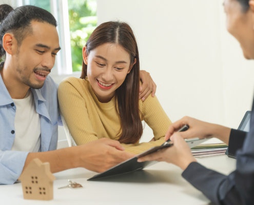Realtor agent giving a key of apartment to new owner after signed lease agreement